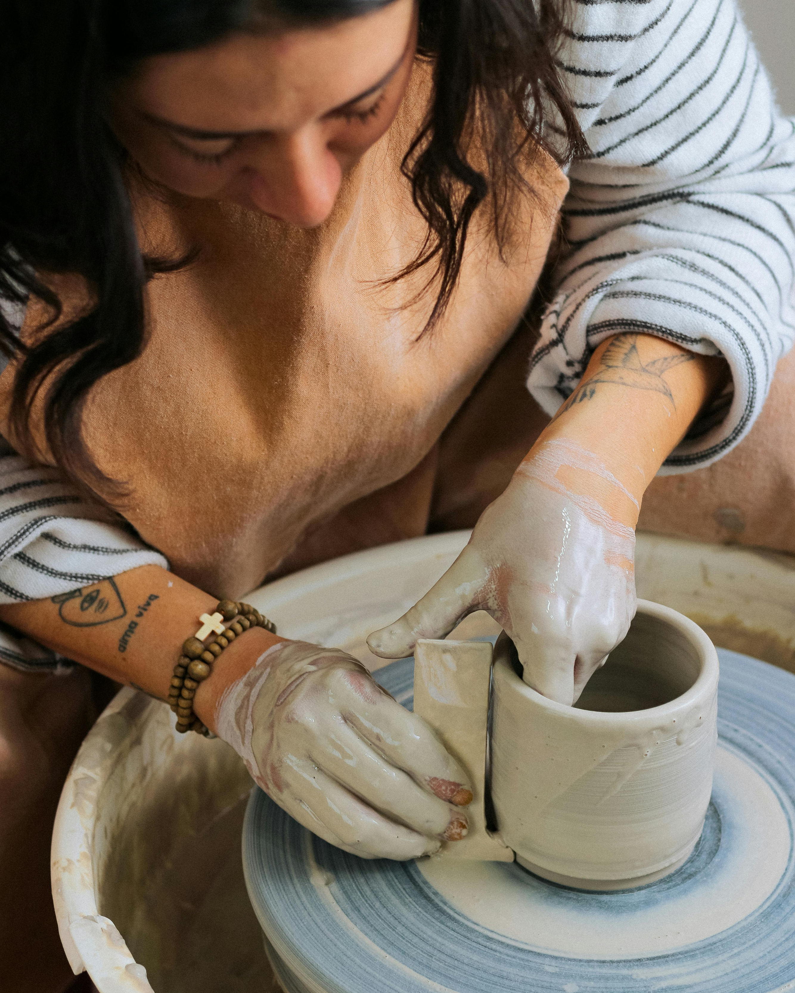 artisan en poterie, maître potier tournant une tasse en terre