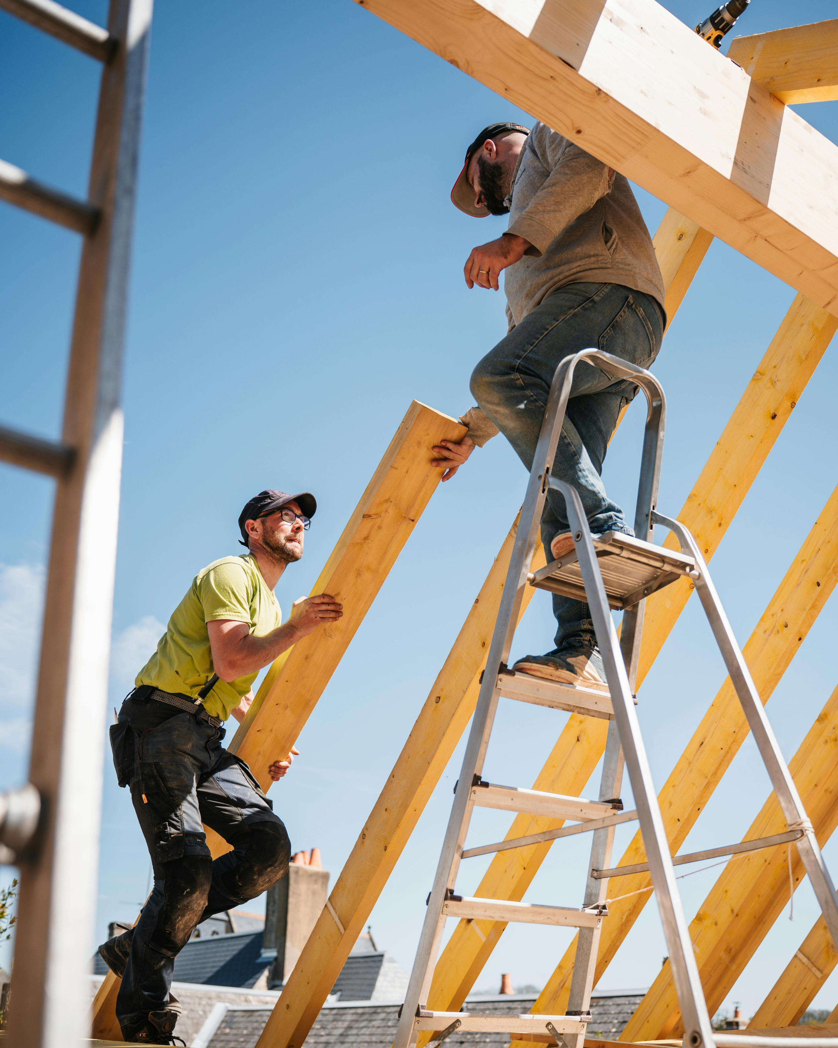duo d'artisans en bâtiment sur le chantier de la charpente d'une maison